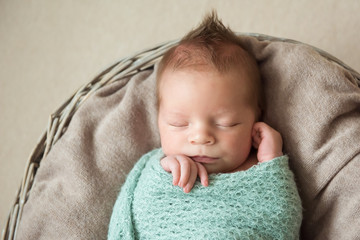 Newborn baby sleeps in a basket hairstyle Mohawk