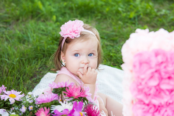 Little girl sitting in the Park, finger in mouth