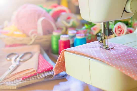 Close up of sewing machine working with pink fabric
