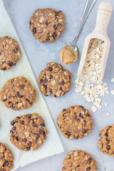 Flourless gluten free peanut butter, oatmeal and chocolate chips cookies on parchment, top view, vertical