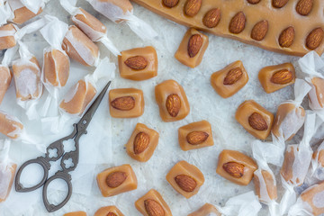 Homemade soft caramel candy with almonds, horizontal, top view