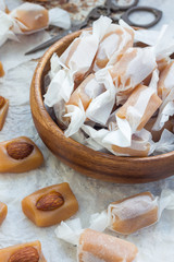 Homemade soft caramel candy with almonds, vertical