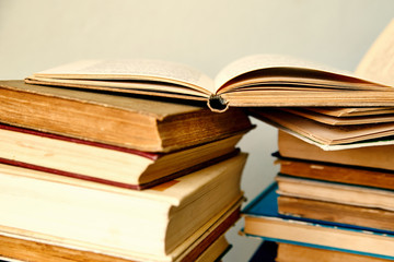 pile of old books and an open book  in hardcover
