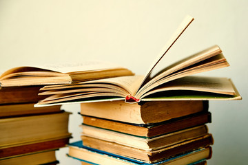 pile of old books and an open book  in hardcover