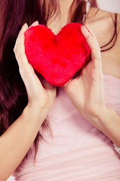 woman holds red heart in hand closeup