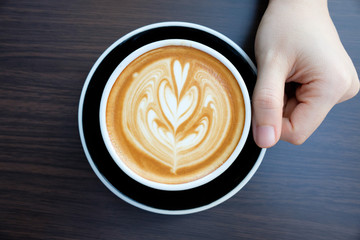 hands holding cup of coffee in coffee shop