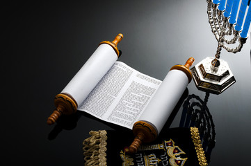 Religion and Judaism concept with the holy Torah and a menorah. The Torah is the jewish holy text / book and a menorah is the traditional branched candle stick specific to Hanukkah © Victor Moussa
