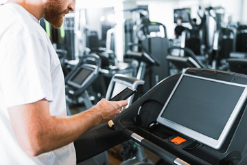 Fototapeta na wymiar Bearded guy in gym at treadmill