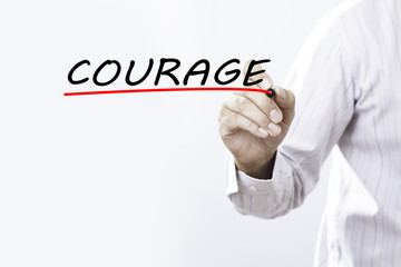 Businessman hand writing COURAGE with red marker on transparent