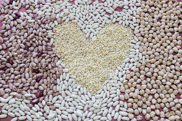 Ortaggi legumi misti fagioli e ceci creando una forma del cuore su tavolo di legno 