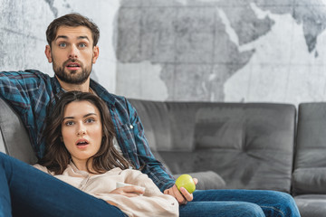 Obraz premium Surprised couple entertaining with tv at home