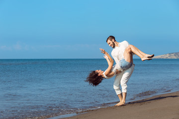 romance on vacation: couple in love on the beach flirting