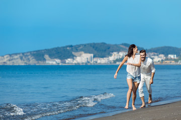 Fototapeta na wymiar happy couple running on the beach