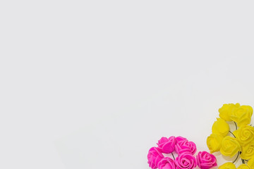 pink and yellow artificial roses on a white background. festive concept for Valentine's day, birthday, wedding, party, holiday