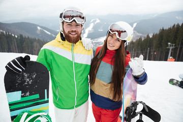 Happy loving couple snowboarders on the slopes