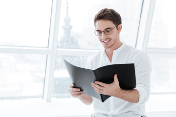 Handsome young man holding folder