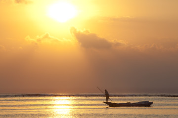 fisher man on boat in sunset bali