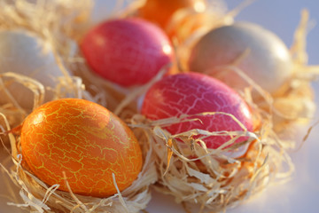 Easter. Pink, beige and orange eggs in the straw 2