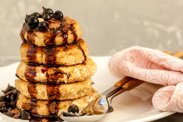 Cottage cheese pancakes with berries and chocolate syrup. Healthy homemade food content.