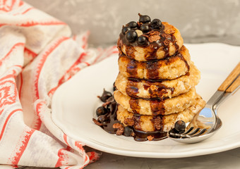 Cottage cheese pancakes with berries and chocolate syrup. Healthy homemade food content.