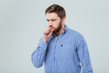 Sick bearded young man stading and coughing