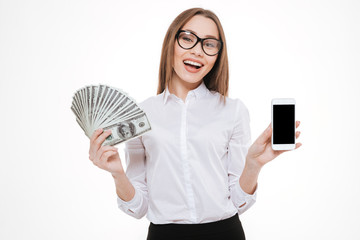 Happy young businesswoman showing money and blank screen mobile phone