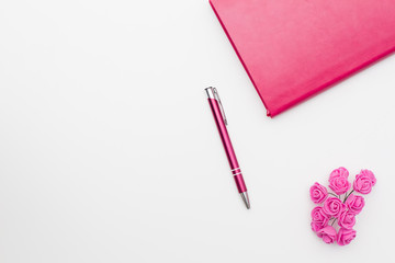 pink diary pen roses on a white background, business minimal concept for women. Flat lay, top view.