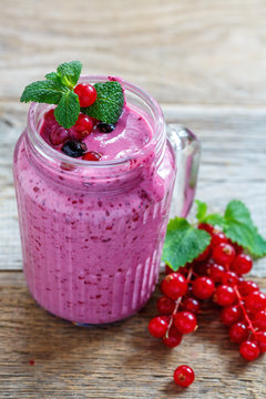 Smoothies made of red and black currants in a glass jar.