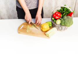 Man preparing a salad, searching for recipes on-line using a laptop hands close up, kitchen tools and food ingredients 