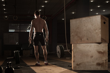 Young muscular man exercising with barbell