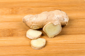 Sliced ginger root with a heart shape isolated on a wood background