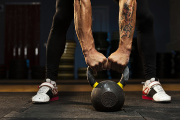 Cropped shot of male hands holding kettlebell.