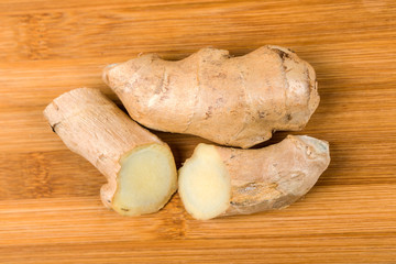 Sliced ginger root isolated on a wood background