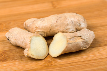 Sliced ginger root isolated on a wood background