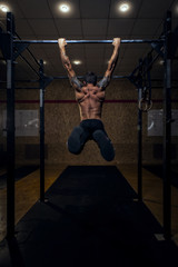 Muscular strong man with on horizontal bar.
