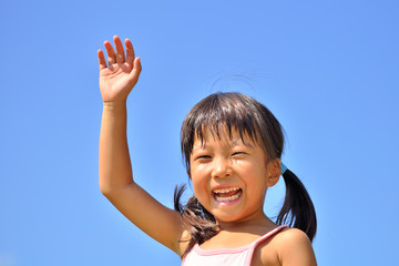 青空で手を上げる女の子