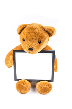Brown fuzzy teddy bear holding a black frame isolated on a white background