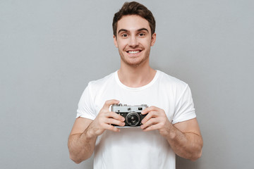 Smiling man holding retro camera