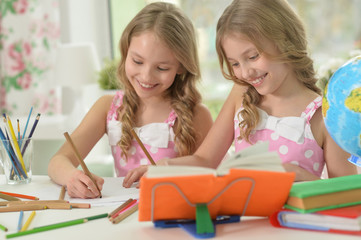 Fototapeta premium two sisters twins doing homework