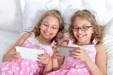 Obraz na płótnie Canvas two sisters twins using smart phones