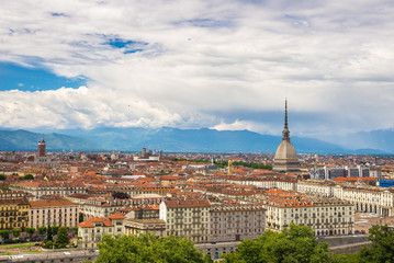 Fototapeta na wymiar Cityscape of Torino (Turin, Italy) with the Mole Antonelliana towering over the buildings. Wind storm clouds over the Alps in the background.
