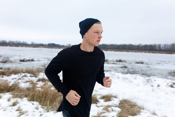 Male Model runs in the winter. winter cold. morning running. regular morning jog. black clothes....