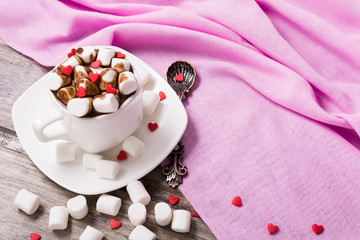 Obraz na płótnie Canvas Hot chocolate in white cup with marshmallow and sweet hearts on the wooden table. Copy space