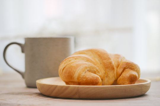 Stock Photo:.Fresh and tasty croissant on old wooden table