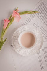 Cup of coffee on the table with a flower