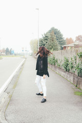 Back view of young beautiful eastern woman wearing hoodie walking outdoor in the city - walking, strolling, autumn concept