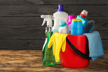 Basket with cleaning product on wooden table with copy space