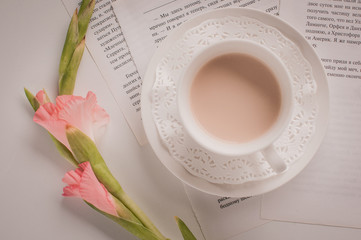 Cup of coffee on the table with a flower