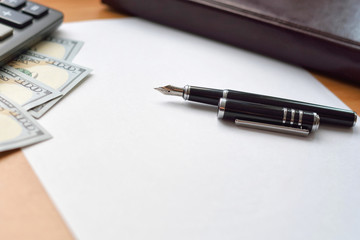 Notebook, money, calculator and pen on desk