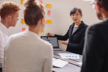 Group of business people discussing data on laptop at meeting